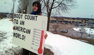person holding Iraq body count poster