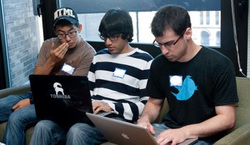 three students on laptops