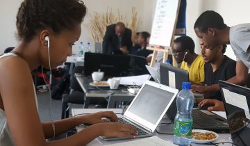 African American woman sitting at table working on laptop computer
