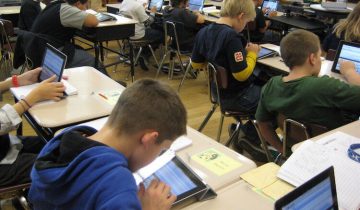 Kids looking at ipads in classroom