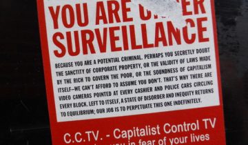 A ripped sign reads in large red capital letters: you are under surveillance
