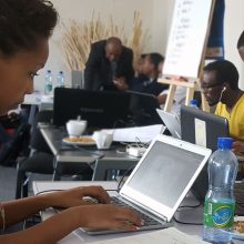 African American woman sitting at table working on laptop computer