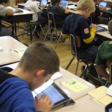 Kids looking at ipads in classroom