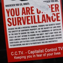 A ripped sign reads in large red capital letters: you are under surveillance