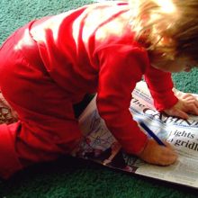child drawing on newspaper