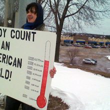 person holding Iraq body count poster