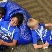 kids laying on ground using tablets